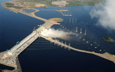Night aerial view of the central part of the dam, with a suspension bridge at the bottom of the dam
