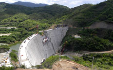 Aerial view of the hydroelectric dam evacuating water surrounded by hydroelectric posts in charge of transporting the energy